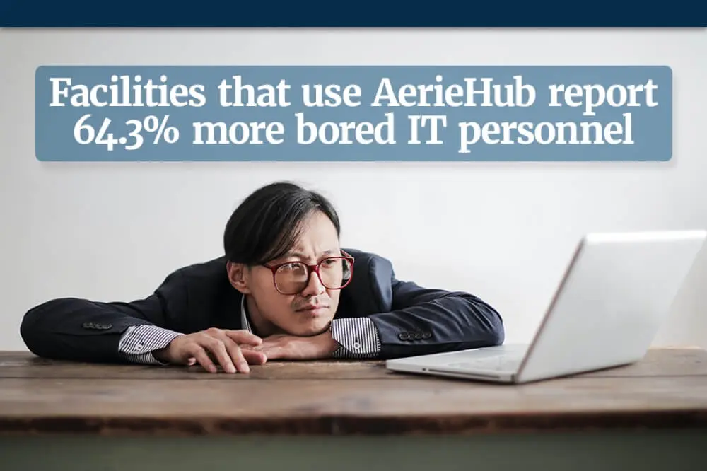 an image of a male employee looking tired staring at a laptop