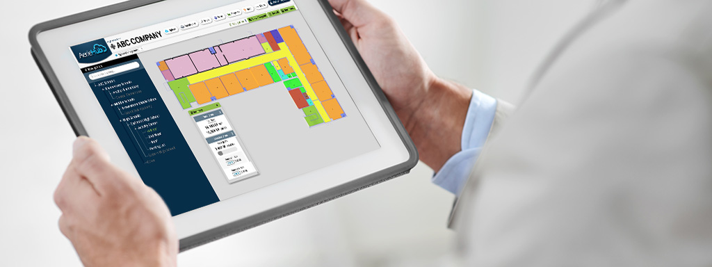A businessman looks at a tablet showing the square footage of his facility.