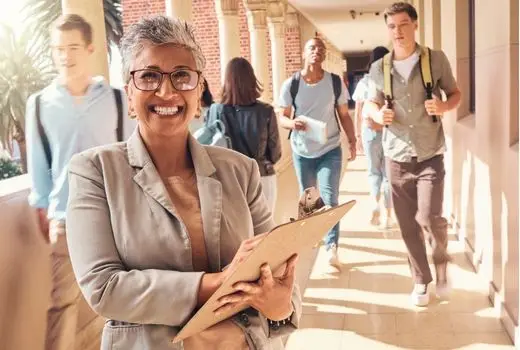 An educator standing in front of a group of students on a university campus