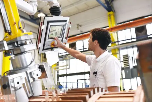 Man adjusts screen in manufacturing plant